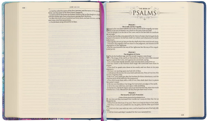 Una Biblia de la Versión del Rey Jacobo, con espacio para tomar notas y abierta, muestra el texto del final del libro de Job y el comienzo de los Salmos, con los Salmos del 1 al 3 visibles en sus páginas.