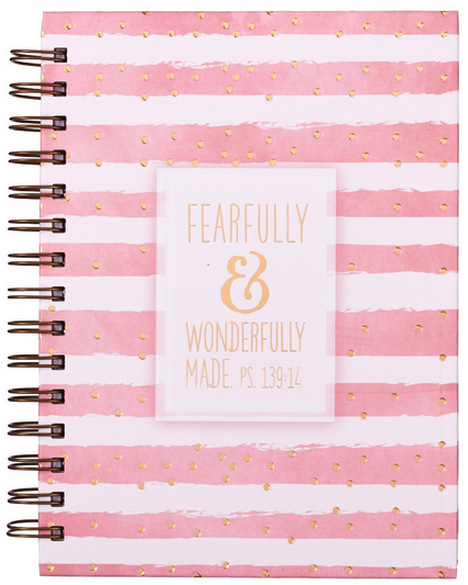 Un cuaderno de espiral con encuadernación metálica, a rayas rosas y blancas, con puntos dorados y la cita bíblica «Hecho de manera maravillosa y admirable. Sal. 139:14» en la portada.