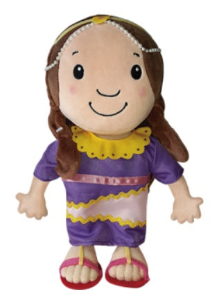 Un peluche de poliéster con el pelo castaño, que lleva un vestido morado con detalles amarillos, una diadema con abalorios y sandalias rojas. Está sonriendo y mirando hacia delante. Tamaño: 30,5 cm x 17 cm (12 x 6,69 pulgadas).