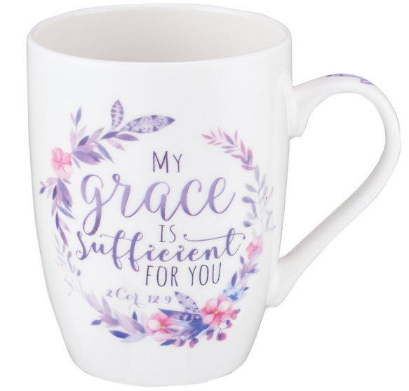 Una taza de cerámica blanca apta para microondas, decorada en la parte delantera con una corona floral morada y el texto «Mi gracia te basta, 2 Cor 12,9», ideal como regalo especial y disponible con una caja de regalo opcional.