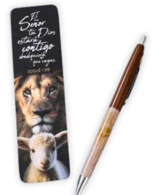 Un marcapáginas con un león y un cordero, en el que aparece el versículo bíblico de Josué 1:9 en español, descansa junto a un bolígrafo marrón y beige sobre un fondo blanco.