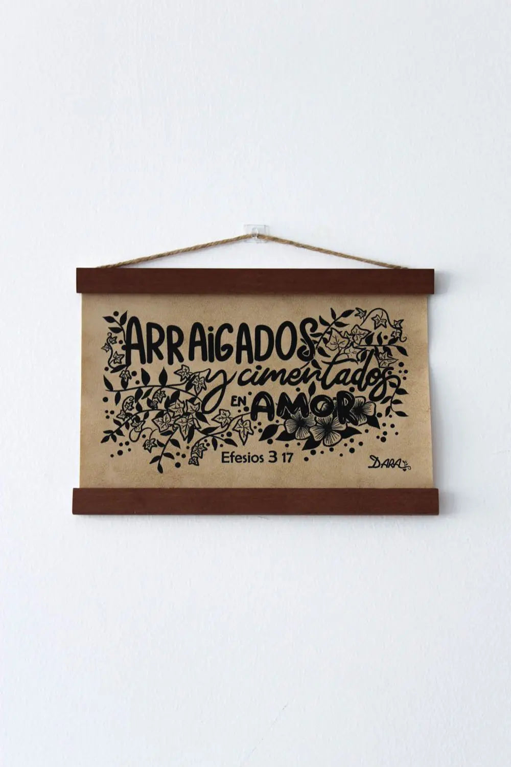 Cuadro para colgar con ilustraciones florales y el texto en español Arraigados y cimentados en amor, Efesios 3:17, ideal para la decoración bíblica.