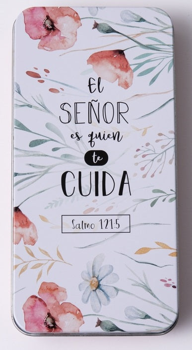 Una caja metálica decorativa con motivos florales y un texto en español que dice: «El Señor es quien te cuida. Salmo 121:5», ideal para guardar un bolígrafo o un llavero.