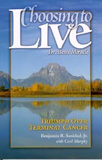 Portada del libro titulado «Choosing to Live: Dr. Ben's Miracle», en la que aparece un paisaje montañoso con árboles y un lago. El subtítulo reza: «Triunfo sobre un cáncer terminal: una historia de sanación por la fe y esperanza frente al cáncer de esófago».