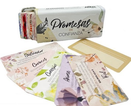 Una caja metálica con la inscripción «Promesas de Confianza», con varias tarjetas de colores dispuestas en la parte delantera, cada una de ellas con texto y motivos florales.