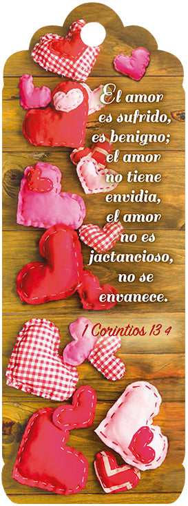 Corazones de tela de distintos tonos rojos y rosas dispuestos sobre una superficie de madera, con un versículo de la Biblia en español, de 1 Corintios 13, sobre el amor, escrito junto a ellos.