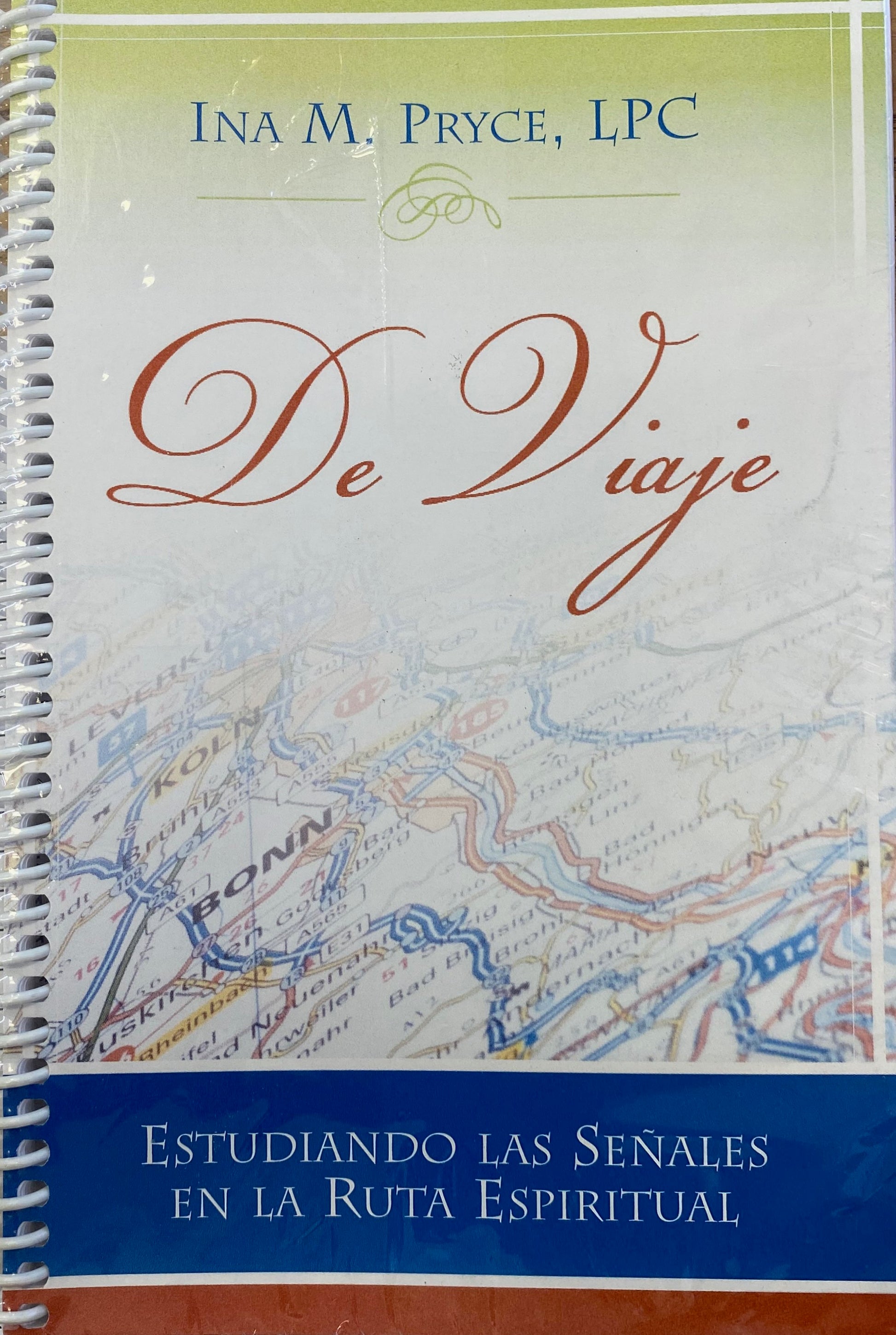 Portada de un libro con encuadernación en espiral titulado *De Viaje*, de Ina M. Pryce, LPC, con un fondo de mapa y el subtítulo *Estudiando las señales en la ruta espiritual*, que explora las señales espirituales a lo largo de tu viaje.