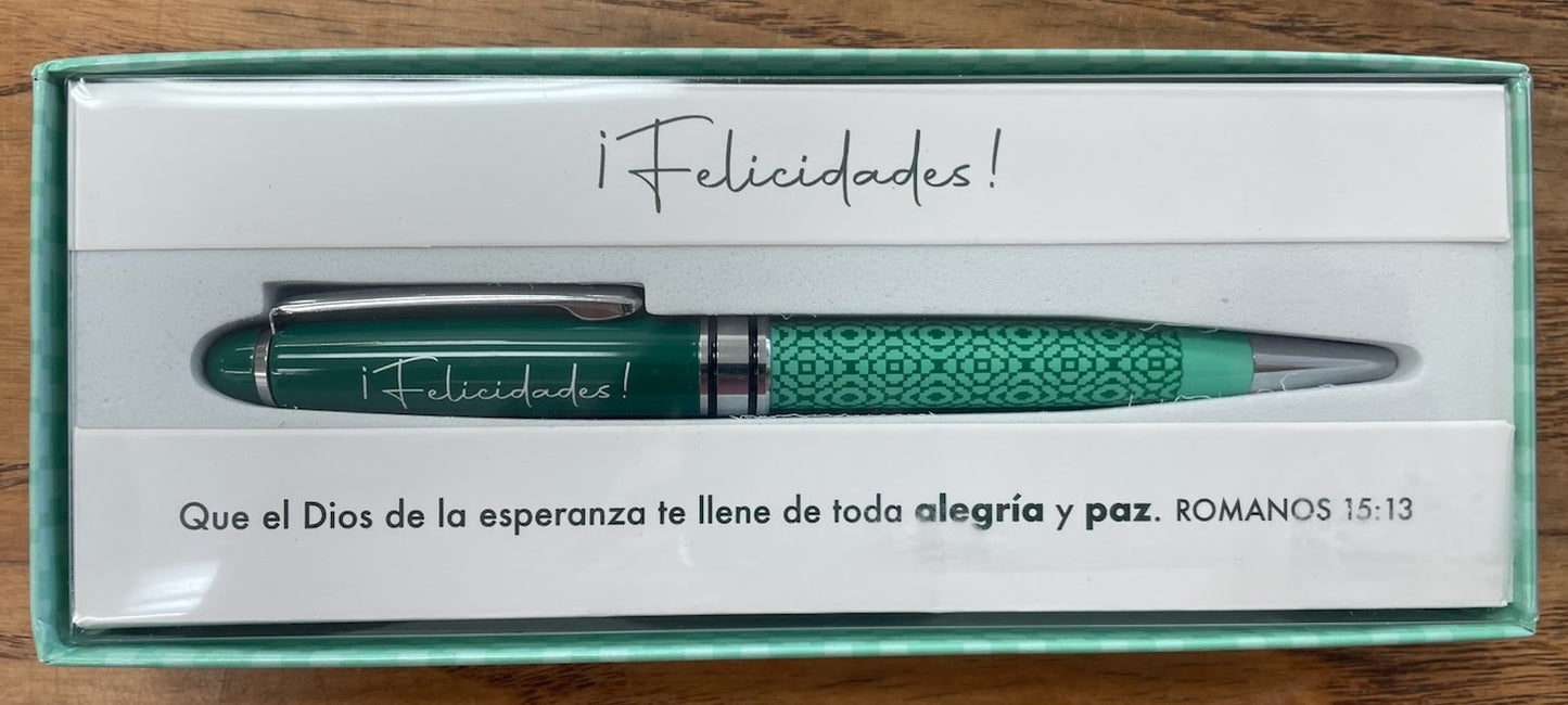 Una pluma verde en una elegante caja de regalo con la palabra «¡Felicidades!» y un mensaje en español que cita Romanos 15:13 sobre la alegría y la paz.