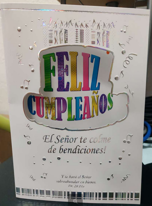 Una tarjeta cristiana de cumpleaños en español, con «Feliz Cumpleaños» en letras de colores, detalles plateados y un versículo bíblico al pie para desear muchas bendiciones.
