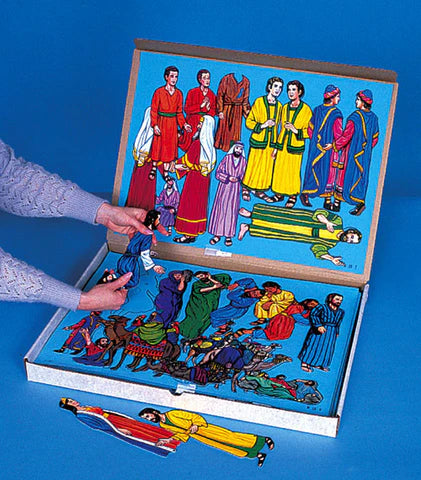 Una persona coloca unas figuras de fieltro ilustradas que representan personajes bíblicos sobre un franelógrafo azul, mientras que en la caja de abajo hay más figuras de fieltro guardadas.