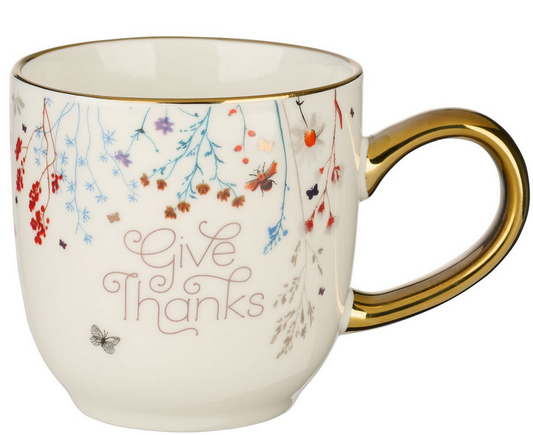 Taza de cerámica con asa de lámina dorada, decorada con motivos florales y con la frase «Give Thanks» impresa en la parte delantera. Se recomienda lavarla a mano. 11 fl oz.