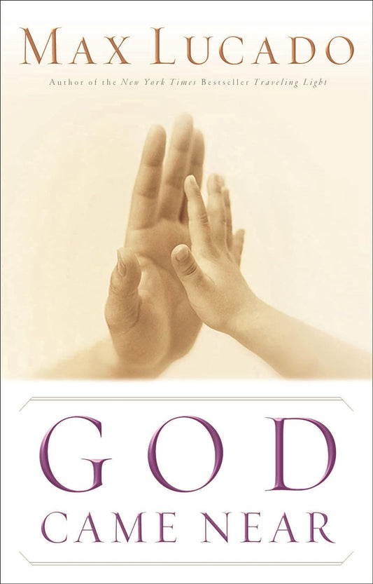 Portada del libro *God Came Near*, de Max Lucado, en la que se ven una mano de adulto y una mano de niño tendiéndose la una hacia la otra sobre un fondo claro, lo que simboliza el abrazo de Dios.