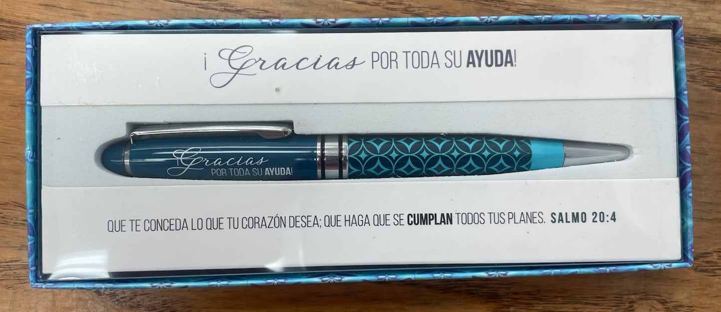 Una pluma azul y plateada con motivos decorativos, presentada en una caja de regalo. La caja lleva impreso un texto en español en el que se expresa gratitud, así como un versículo bíblico, el Salmo 20:4.