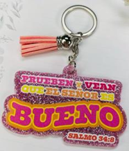 Llavero con una inscripción brillante en español que dice «Prueben y vean que el Señor es bueno», un versículo bíblico del Salmo 34:8, y una borla rosa.