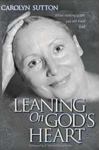 Portada en blanco y negro en la que aparece una mujer sonriente con la cabeza apoyada en la mano. Título: *Leaning On God’s Heart*, de Carolyn Sutton. Una historia inspiradora sobre la fe en Dios: cuando ya no te queda nada, siempre te queda Dios.