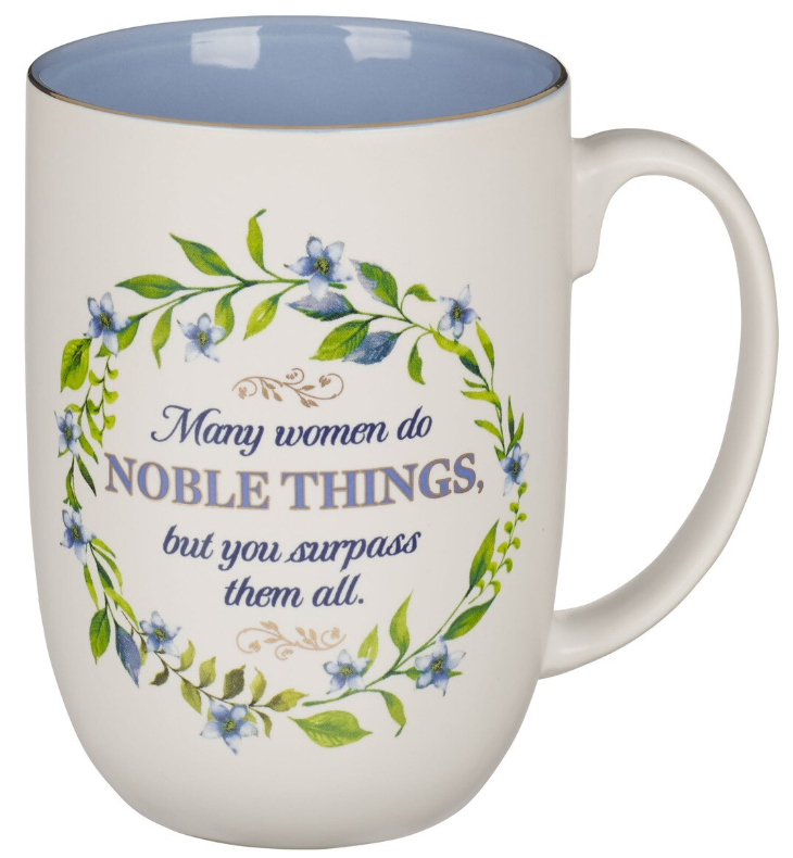 Una taza de cerámica blanca (15 fl oz) con un diseño de corona floral y el siguiente texto: «Muchas mujeres hacen COSAS NOBLES, pero tú las superas a todas». Se recomienda lavarla a mano; no apta para el lavavajillas.