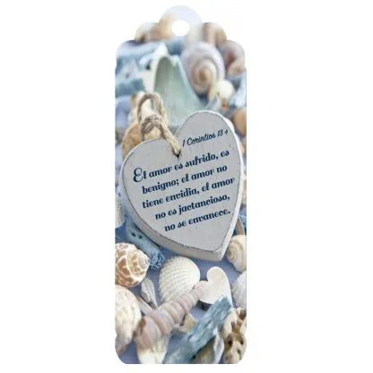 Una placa con forma de corazón en la que figura un versículo de la Biblia en español, extraído de la Epístola a los Corintios, rodeada de conchas marinas y motivos decorativos inspirados en la playa: perfecta para compartir amor y bendiciones en tu hogar.