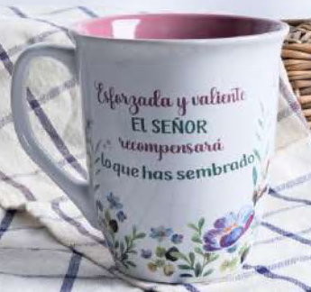 Taza blanca con diseño floral y un texto en español que reza: «Esforzada y valiente. El Señor recompensará lo que has sembrado», sobre un fondo de tela. Esta hermosa taza de 14 oz cuenta con un interior a todo color y viene presentada en una caja a todo color, perfecta para regalar o alegrar tus momentos de café.