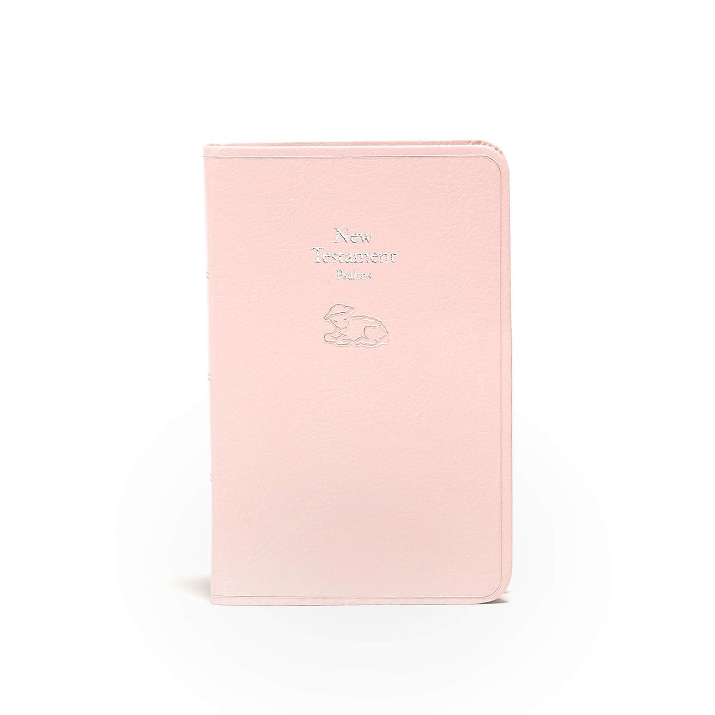 Un ejemplar del Nuevo Testamento para bebés de la versión KJV, de color rosa claro, que incluye los Salmos y una ilustración de un cordero en relieve plateado en la portada, representado de pie sobre un fondo blanco; ideal como regalo para la dedicatoria de un bebé o como Biblia de recuerdo.