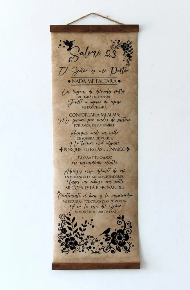 Un rollo decorativo colgado en una pared blanca muestra el Salmo 23 en español, adornado con motivos florales y de pájaros en negro. Perfecto como arte de pared cristiano, proclama de forma hermosa: «El Señor es mi pastor».