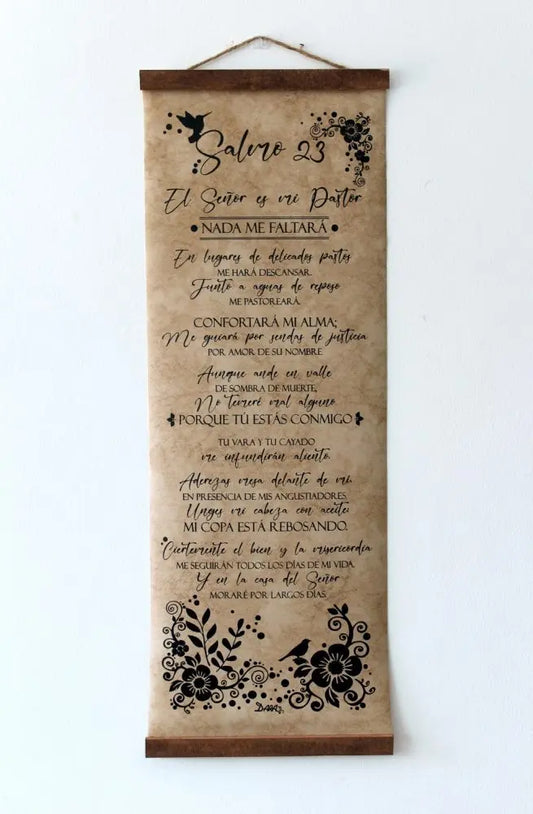 Un rollo decorativo colgado en una pared blanca muestra el Salmo 23 en español, adornado con motivos florales y de pájaros en negro. Perfecto como arte de pared cristiano, proclama de forma hermosa: «El Señor es mi pastor».