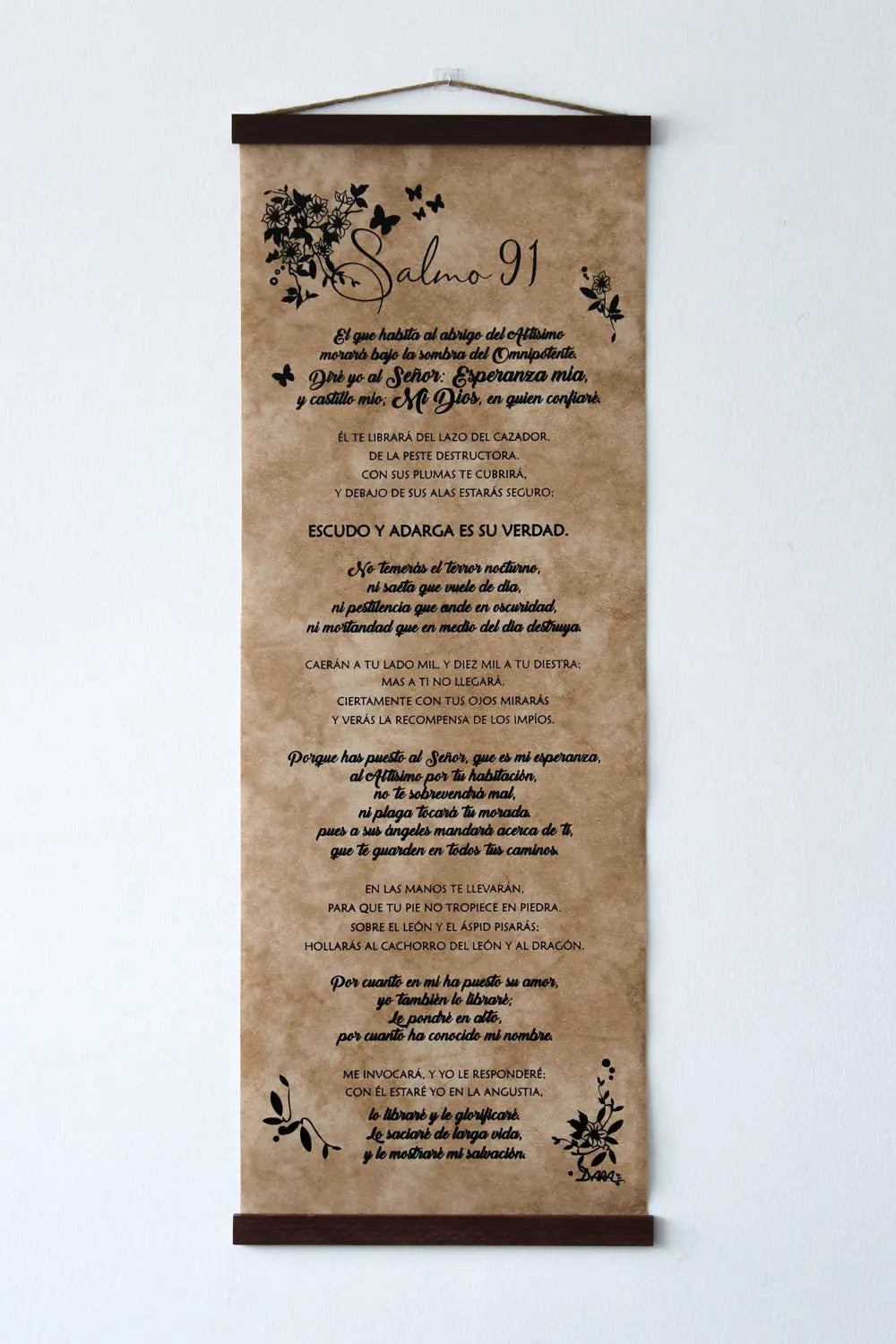 Un rollo colgante decorado con ilustraciones botánicas y en el que figura el texto del Salmo 91, que sirve como pieza decorativa de arte religioso.