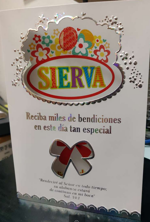 Tarjeta de felicitación con la palabra «SIERVA» en colores vivos y adornos florales. Debajo, se lee «Reciba miles de bendiciones de cumpleaños en este día tan especial» en español, junto con la ilustración de un lazo y un versículo bíblico; perfecta como tarjeta religiosa.