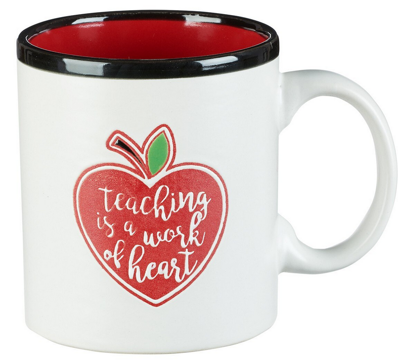 Taza de gres blanco con el interior rojo y el borde negro, decorada con el dibujo de una manzana y el texto «teaching is a work of heart» en el lateral. Apta tanto para el microondas como para el lavavajillas, lo que facilita su uso y limpieza.