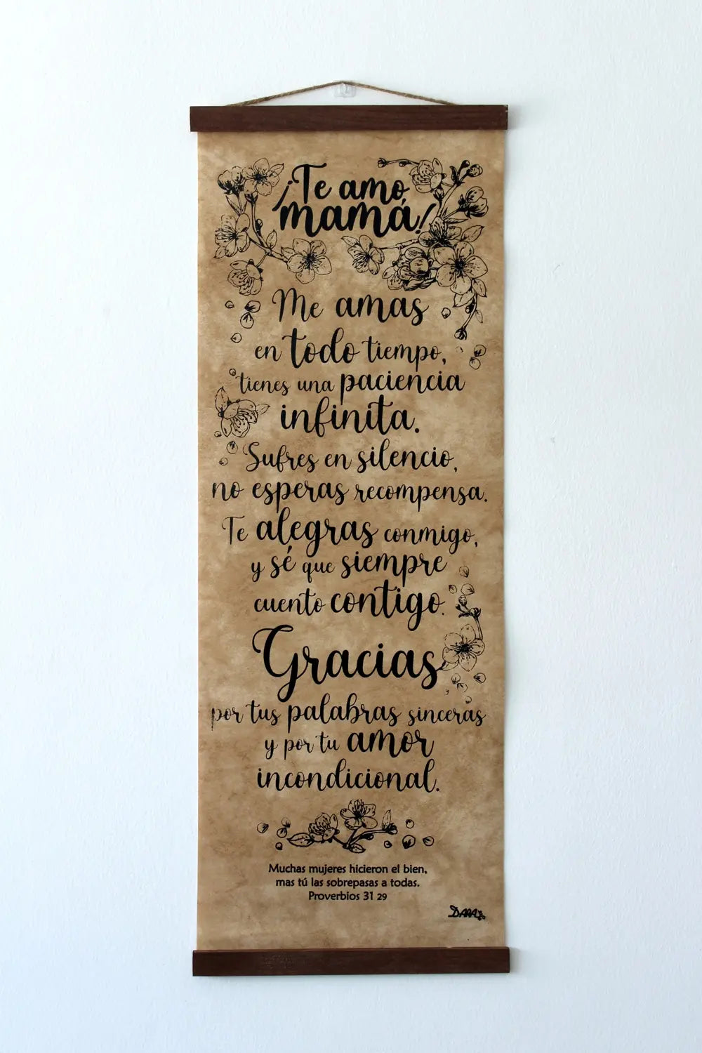 Un rollo decorativo para colgar en la pared con un mensaje en español que expresa amor y gratitud hacia una madre, con ilustraciones florales y la cita de Proverbios 31, 29 en la parte inferior; ideal como regalo religioso de decoración cristiana.