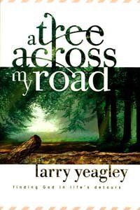 Portada del libro *A Tree Across My Road*, de Larry Yeagley, en la que aparece un árbol caído que bloquea un sendero en el bosque, con la luz del sol filtrándose entre las copas de los árboles: una imagen conmovedora que invita a la reflexión o al debate en grupo.