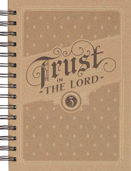 Un cuaderno marrón con encuadernación de espiral y una cubierta decorativa en la que se lee «Confía en el Señor», con páginas rayadas para tomar notas y escribir reflexiones.