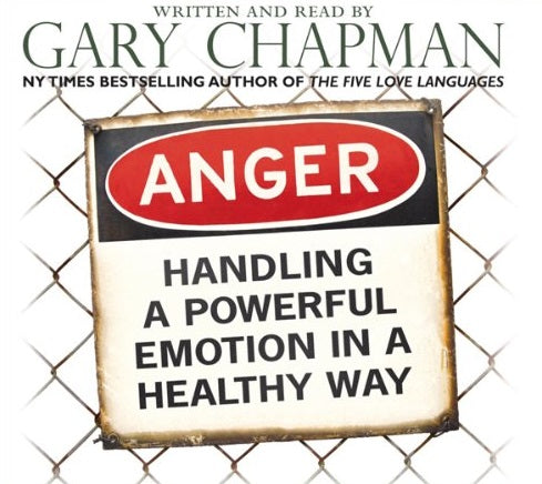 En una valla metálica se ve un cartel en el que se lee «La ira: cómo gestionar una emoción intensa de forma saludable», con el nombre de Gary Chapman encima.