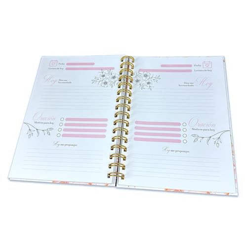 Libreta devocional de espiral abierta con motivos florales, que incluye secciones para la fecha, tareas, notas y reflexiones, con encabezados en rosa y páginas rayadas: perfecta para tu diario con Dios.