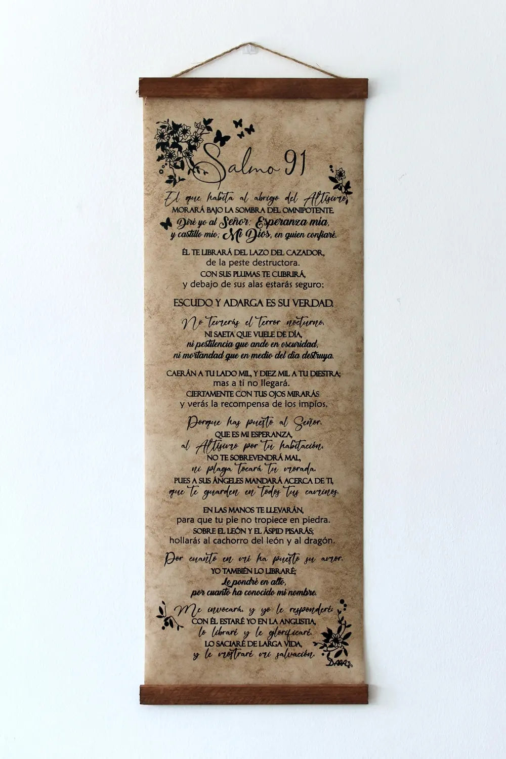 Un rollo decorativo colgado muestra el Salmo 91 en español, que simboliza la protección divina, con ilustraciones de flores y pájaros sobre papel envejecido con aspecto de pergamino.
