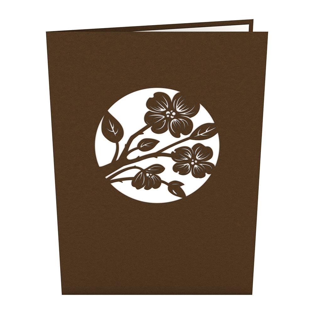 Una tarjeta de felicitación marrón con un diseño circular recortado que representa una rama con flores y hojas, en formato 5 x 7, ideal para cualquier ocasión especial.