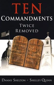 Portada del libro titulado *Ten Commandments Twice Removed*, de Danny Shelton y Shelley Quinn, en la que aparecen unas tablas de piedra expuestas al público, una bandera de Estados Unidos, un edificio con cúpula y el campanario de una iglesia.