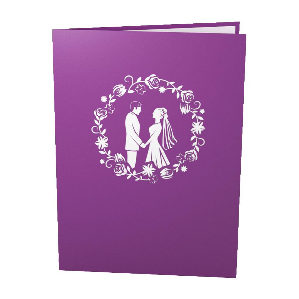 Una tarjeta morada de 5 x 7 muestra la silueta blanca de una pareja cogida de la mano, rodeada por un diseño de corona de flores en la portada.