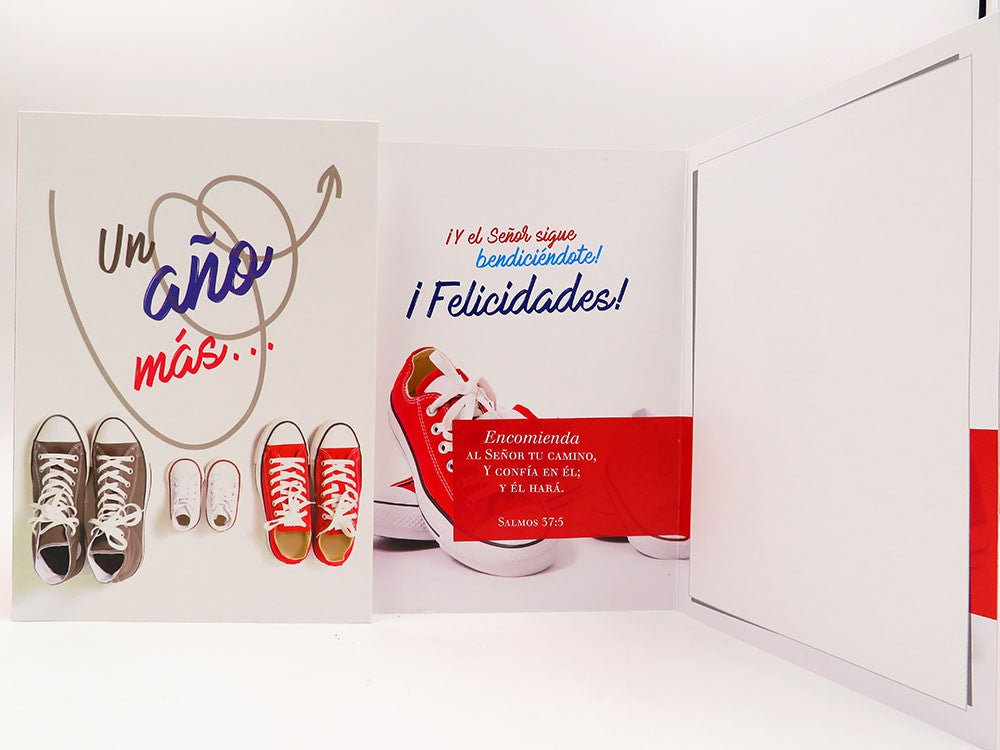 Tarjeta de alta calidad en español con ilustraciones de cuatro pares de zapatillas y mensajes que celebran un año más, las bendiciones y la confianza en Dios, basada en el Salmo 37:5. Incluye sobre y funda protectora.