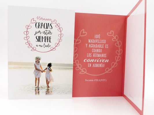 Tarjeta de felicitación con dos niñas vestidas de blanco junto al agua en la portada; en el interior, un mensaje en español sobre la armonía entre hermanos con una referencia a un versículo de la Biblia. Incluye sobre y viene en una bolsa protectora para regalarla con total seguridad.