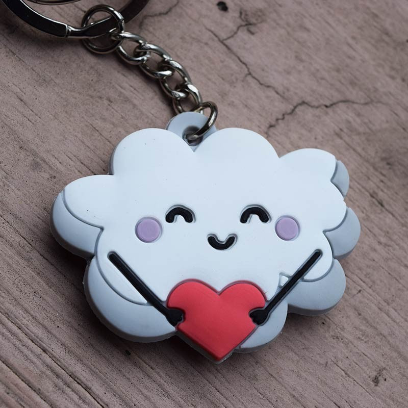 Un llavero divertido con una nube sonriente que sostiene un corazón rojo, inspirado en 1 Corintios 16:14, ideal como regalo cristiano. Perfecto para colocarlo sobre cualquier superficie de madera.