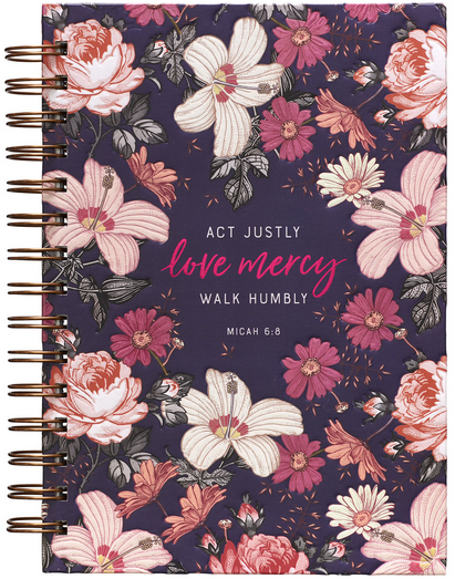 Un cuaderno de tapa dura con encuadernación en espiral y detalles florales, con el texto «Actúa con justicia, ama la misericordia y camina con humildad. Miqueas 6:8» en la portada y páginas rayadas con versículos bíblicos en su interior.