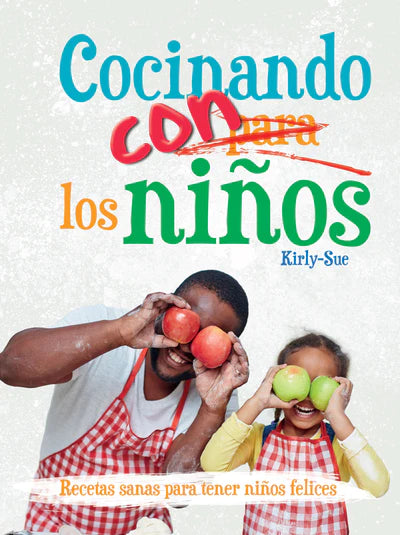 Un adulto y un niño, con delantales rojos, sonríen mientras sostienen fruta ante sus ojos; junto a ellos aparece el título del libro en español *Cocinando para los niños* y un subtítulo que habla de «recetas veganas y saludables para niños felices»: comidas perfectas para niños.