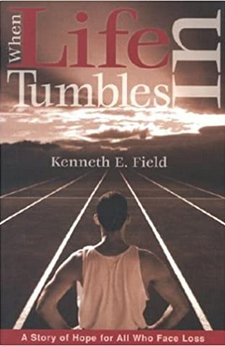 Portada del libro *When Life Tumbles In*, de Kenneth E. Field, una novela inspiradora, en la que aparece una persona en una pista mirando hacia un cielo nublado por el que se asoman rayos de sol.