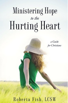 Portada del libro *Ministering Hope to the Hurting Heart*, de Roberta Fish, LCSW. Una mujer con un sombrero para el sol y un vestido verde aparece de pie en un campo, simbolizando la sanación cristiana y la esperanza para los corazones heridos.