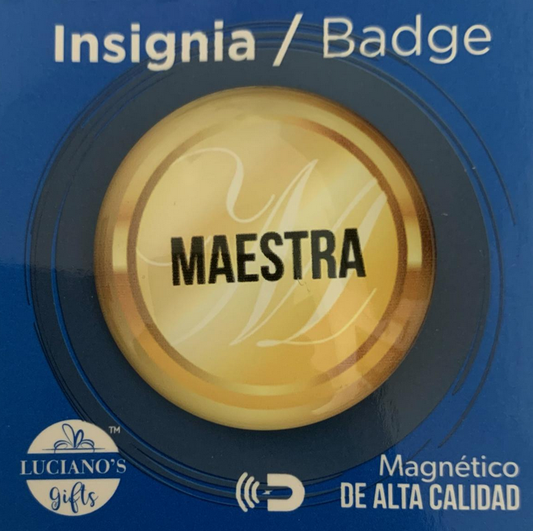 Insignia redonda de oro con la palabra «MAESTRA» en letras negras, en un estuche azul con la etiqueta «Insignia / Badge» y «distintivo con imán de alta calidad». Logotipo de Lucianos Gifts en la esquina inferior izquierda.
