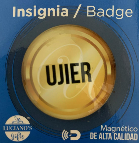 Una insignia redonda de color amarillo con la palabra «UJIER» en letras negras, presentada en un embalaje azul con la etiqueta «Insignia / Badge» y «Magnético DE ALTA CALIDAD»; este distintivo con imán es ideal para un uso práctico y profesional.