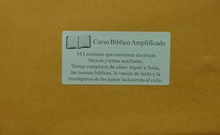 En una etiqueta pegada en un sobre marrón se lee «Curso Bíblico Amplificado», que describe 34 lecciones en hojas sueltas con lecciones y enseñanzas bíblicas en español, junto a el icono de un libro abierto.