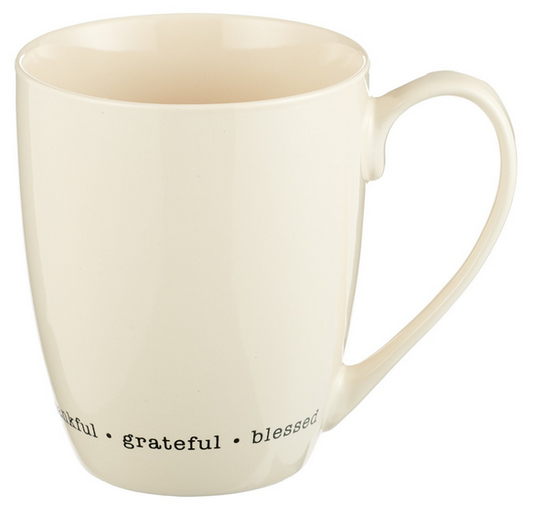 Una taza de cerámica de color crema con las palabras «thankful • grateful • blessed» impresas en negro cerca de la base. Apta tanto para el lavavajillas como para el microondas, para mayor comodidad en el día a día.