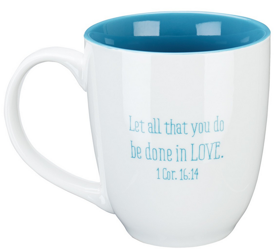 Taza de cerámica blanca con el interior y el asa azules, en cuyo lateral aparece impreso en letras azules el texto «Que todo lo que hagáis se haga con AMOR. 1 Cor. 16:14». Apta para microondas y con un esmalte sin plomo, ideal para el uso diario.