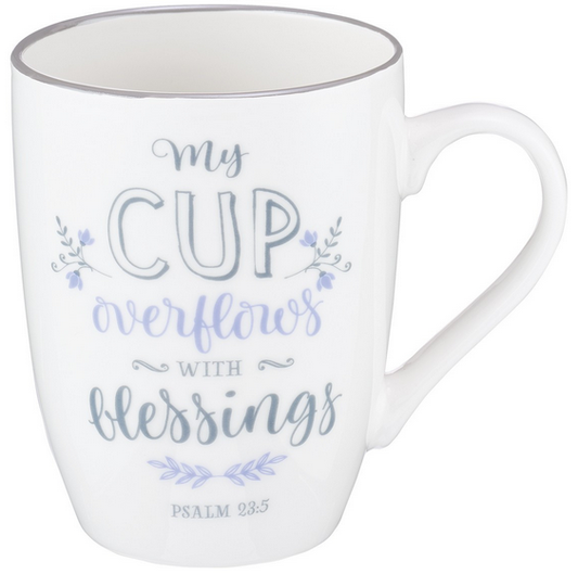 Taza de cerámica blanca, de 12 fl oz, con la frase «Mi copa rebosa de bendiciones, Salmo 23:5» en letras decorativas y pequeños detalles florales. Presentada en una caja de regalo, ideal para regalar.